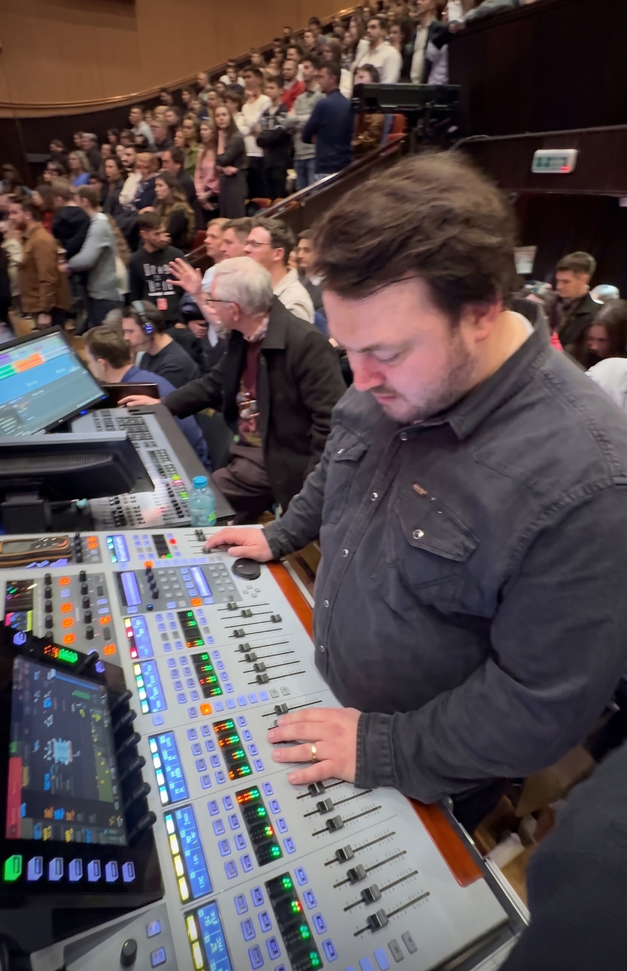Emanuel Daniciuc mixing front of house in a packed concert hall